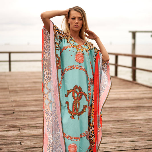 Woman in floral silk kaftan on beach